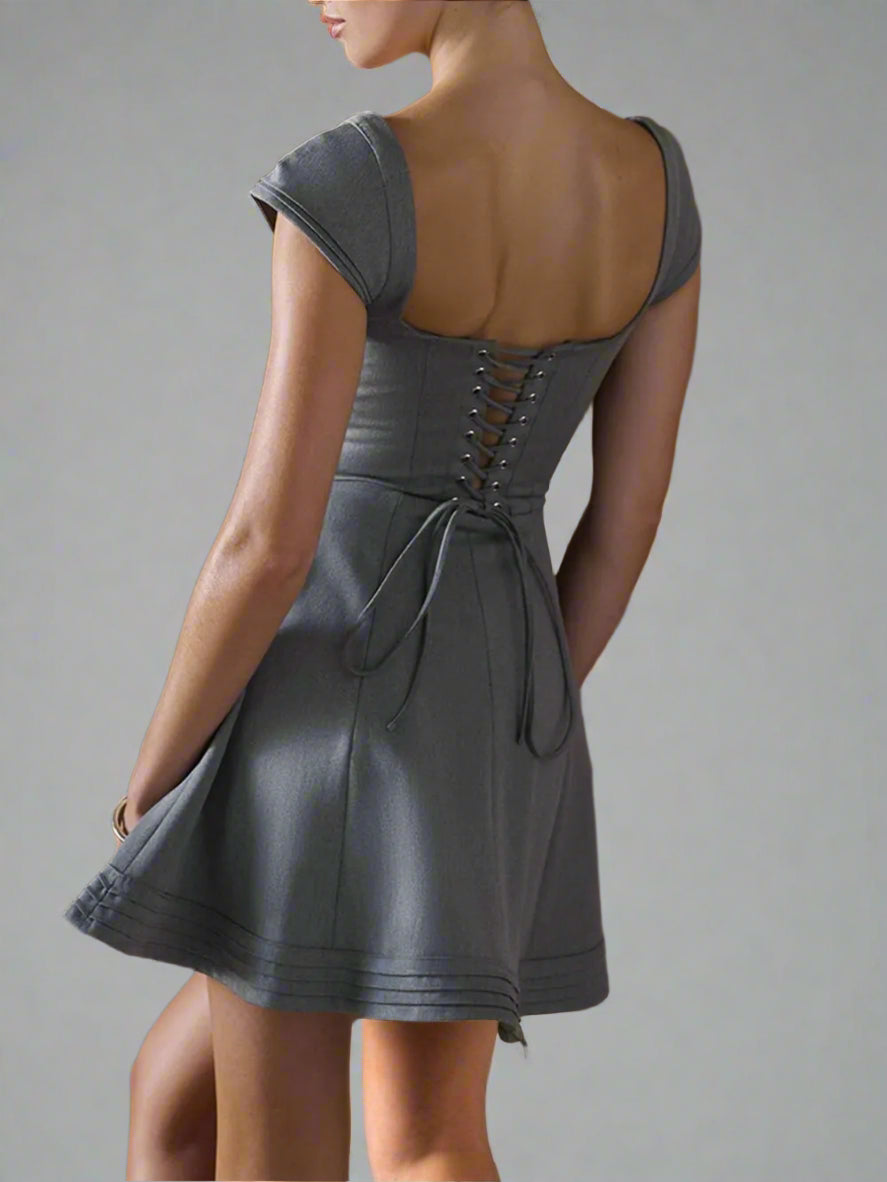 A woman is wearing Devine Lace-Up Sweetheart Neck Cap Sleeve Mini Dress
