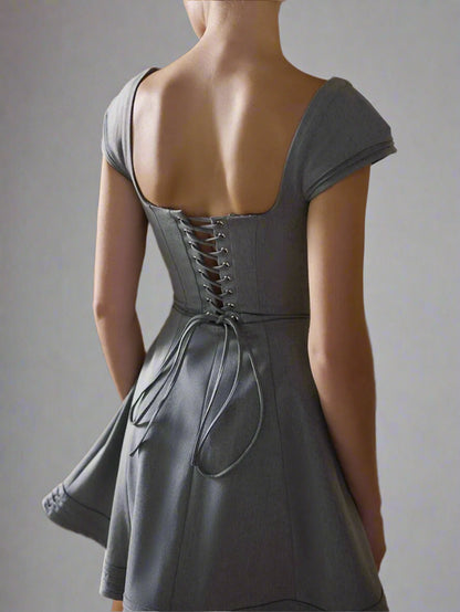 A woman is wearing Devine Lace-Up Sweetheart Neck Cap Sleeve Mini Dress
