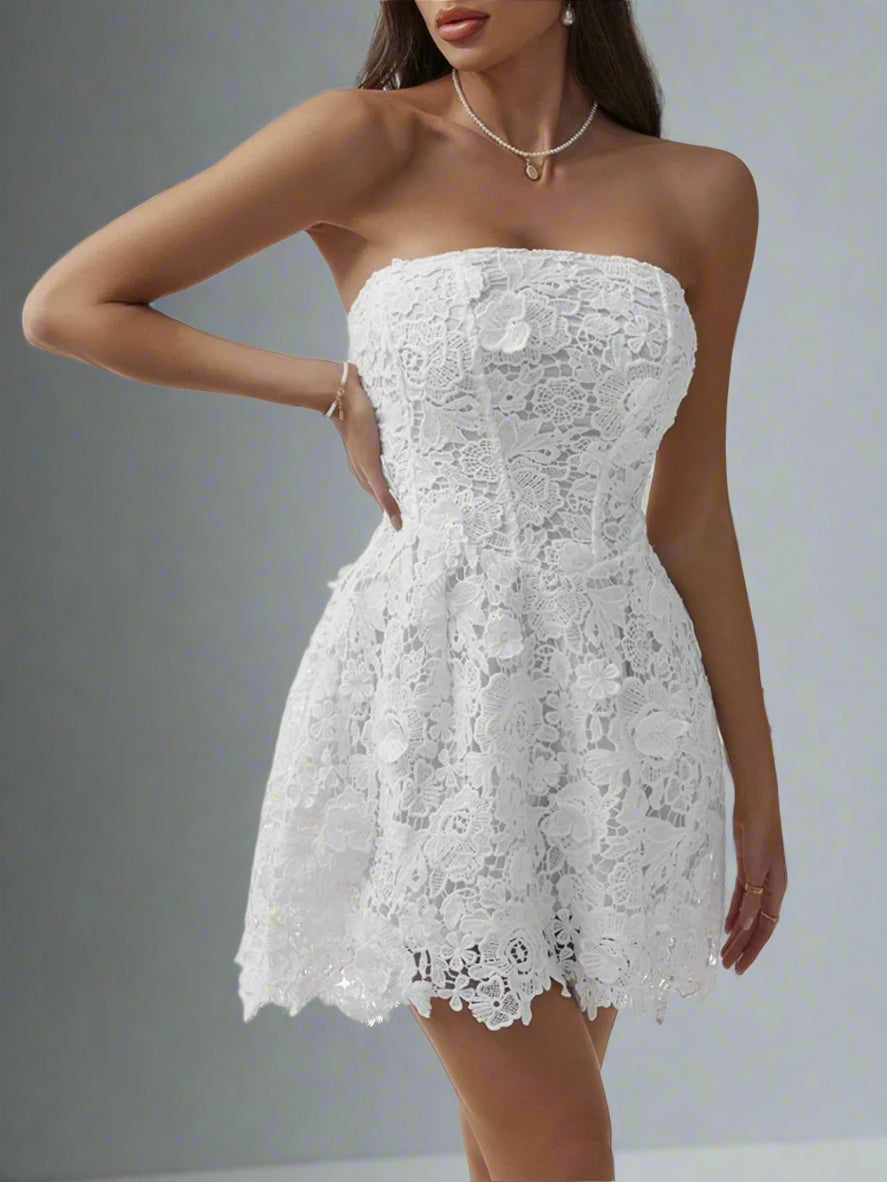 A woman is wearing The Lacey Mini Dress in White

