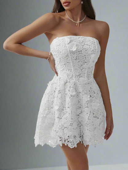 A woman is wearing The Lacey Mini Dress in White
