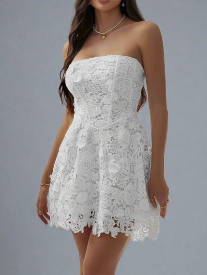 A woman is wearing The Lacey Mini Dress in White
